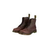 Botas de cuero marrón Dr. Martens 1460 con cordones negros, costuras amarillas características y suela de goma con cámara de aire. Cuentan con forro interior de piel sintética y tirador trasero con el logo de la marca.