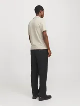 Polo de punto color beige con cuello polo, cierre frontal parcial con cremallera y mangas cortas. Presenta un tejido estructurado y corte regular.