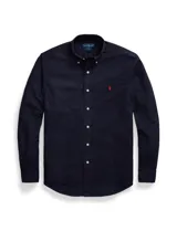 Camisa blanca de corte clásico, confeccionada en tejido oxford de algodón. Presenta cuello button-down, manga larga con puños abotonados y logo bordado en el pecho.