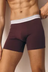 Pack de tres calzoncillos tipo trunk en color borgoña, blanco y marrón, con cintura elástica blanca con rayas horizontales. Confeccionados con tecnología Lycra® Xtra Life™.