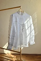 Blusa blanca de lino con cuello Galón estructurado y detalle de encaje.