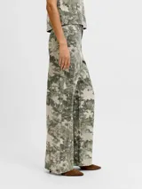 Pantalón de tiro alto, corte recto y amplio, confeccionado en sarga resistente con un estampado all-over camuflado en tonos verde militar y beige, con líneas verticales de pespuntes claros. Cuenta con cierre de cremallera y bolsillos delanteros y traseros.
