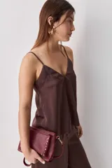 Top negro de breteles finos con escote en V y diseño minimalista, confeccionado en tela fluida y suave.