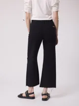 Pantalón jean color beige, de tiro alto y pierna ancha con terminación desflecada.