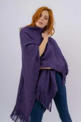 Ruana artesanal tejida en telar manual, color violeta, con textura rústica y terminaciones con flecos en los bordes. Incluye etiqueta de cuero con la marca Pura Lana.