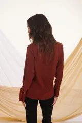 Camisa azul marino de corte clásico, con cuello camisero, mangas largas con puños abotonados y cierre frontal con botones.