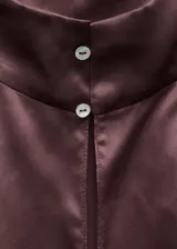Blusa de seda con cuello alto y diseño sin mangas, de corte recto y acabado satinado.