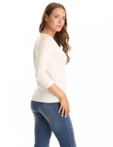 Buzo de tejido fino en color blanco, con cuello redondo y mangas tres cuartos tipo raglán. Presenta un detalle decorativo de tachas metálicas a lo largo de las mangas.