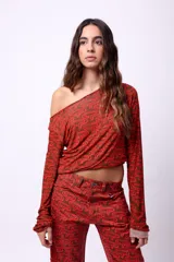 Top de manga larga confeccionado en microtul doble con diseño estampado gráfico en tonos marrón y rojo. Presenta un ajuste al cuerpo y escote redondo.