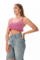 Top crop tejido color fucsia con breteles finos y terminación con flecos.