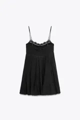 Vestido corto negro de gasa con escote recto y tirantes finos ajustables. El corpiño tiene fruncido elástico y el ruedo es escalonado con volados. Presenta un detalle de encaje a tono en el borde del escote.