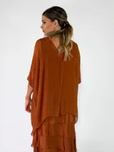 Blusa de viscosa color mostaza, con escote en V, mangas cortas holgadas y diseño amplio.