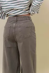 Pantalón de denim color marrón, de tiro medio-alto y calce wide leg con pierna amplia.