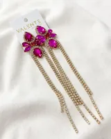 Aros colgantes con forma de flor con piedras fucsia y strass dorados.