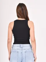 Musculosa negra de tejido rib al cuerpo, con cuello redondo y diseño sin mangas.