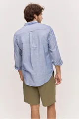 Camisa de manga larga de lino con diseño a rayas en tonos celestes y blancos, cuello camisero clásico y cierre frontal de botones.