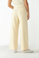 Pantalón de lana fina color crema, de tiro alto y pierna recta ancha.