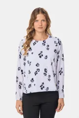 Blusa blanca con estampado de lunares negros, de manga larga y cuello redondo con abertura en la espalda.