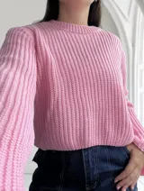 Sweater de punto color rosa con cuello redondo y mangas abullonadas.