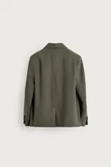Blazer de corte relaxed fit confeccionada en tejido con mezcla de modal, en color verde militar. Presenta cuello con solapas de muesca, cierre frontal con un botón, bolsillos de vivo en el pecho y bolsillos con solapa en la cadera. Forro interior a rayas y abertura en el centro de la espalda.