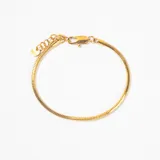 Pulsera tipo cadena de serpiente en color dorado, con cierre de mosquetón y cadena de alargue con dije circular pequeño.