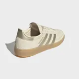 Championes Adidas Handball Spezial de gamuza en color beige, con las clásicas tres tiras metalizadas en tono dorado, talón a juego, inscripción "SPEZIAL" lateral y suela de goma translúcida.