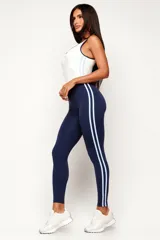 Monopieza deportiva color azul marino y blanco, con efecto bicolor que simula la combinación de una musculosa y calzas. Presenta dos tiras laterales en celeste y breteles medios.