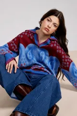 Sweater de punto con cuello polo, diseño de estampado paisley y flores en tonos azul y bordó, de corte holgado y manga larga.