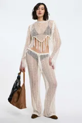 Pantalón blanco de tejido calado, con cintura elástica y cordón ajustable, de corte recto y holgado.