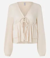 Blusa color crema con escote en V, mangas largas y lazo en el busto.