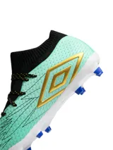 Championes de fútbol Umbro modelo Ignis HG, con diseño de botín de corte medio en color amarillo con detalles en azul marino y suela azul con tapones naranjas.