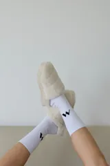 Pantuflas tipo slides forradas en piel sintética, con base de goma de 4 cm de altura y plantilla con logo grabado.