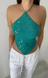 Top verde con lentejuelas, escote halter y espalda descubierta.