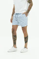 Short de baño con estampado floral en tonos azules, cintura elástica con cordón ajustable, bolsillos laterales y bolsillo trasero.