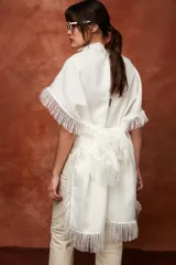 Chal de tejido liviano con lino, color blanco, con terminaciones desflecadas y diseño versátil para usar como capa.