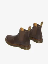 Bota Chelsea Dr. Martens 2976 YS Crazy Horse, color marrón, fabricada con cuero Crazy Horse desgastado. Presenta paneles elásticos laterales, costuras amarillas Goodyear y una tira de tela amarilla con el logo de la marca en la parte trasera.
