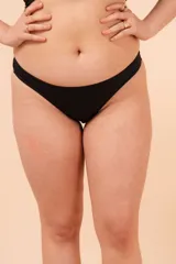 Bombacha vedetina tiro medio color negro, con laterales y cola finos. Confeccionada con tela que contiene fibra LYCRA
 XTRA LIFE.