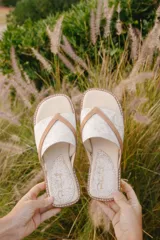 Sandalias de cuero color beige con estampado craquelado y tiras cruzadas color marrón.