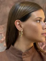 Aros tipo argolla de bronce con diseño irregular y detalles de esferas pequeñas.