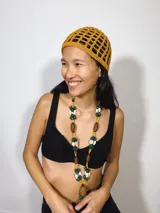 Gorro tipo casquete rojo de crochet con diseño calado.