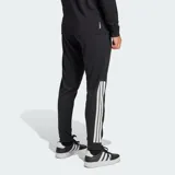 Pantalón deportivo Adidas de corte cónico, color negro con las icónicas tres tiras blancas en los laterales. Cuenta con cintura elástica con cordón de ajuste, bolsillos laterales con cierre y cierres en los tobillos para mayor practicidad.