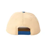Gorra Rip Curl modelo Aots Ty Williams, de diseño bicolor con cuerpo en tono beige y visera curva en color celeste. Cuenta con un bordado frontal detallado que ilustra a personas cargando tablas de surf junto al logotipo de la marca.