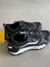 Championes Vans Crosspath XC, color negro, con detalles en gris claro y blanco. Diseñadas para uso todoterreno urbano, cuentan con parte superior de malla de PET reciclado, ante y textiles, tratamiento DWR, suela Vibram XS TREK EVO y entresuela UltraCush™.