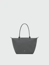Bolso tote grande Le Pliage One de Longchamp, color negro, con asas superiores y solapa de cierre con botón a presión.