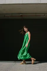 Vestido largo color beige, de seda, con breteles finos ajustables y volado en la espalda.