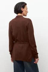 Ruana de tejido de punto color marrón chocolate, con cuello en V y diseño abierto, sin mangas.