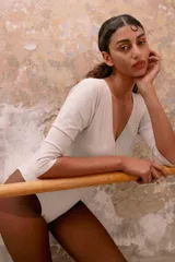 Body de algodón con escote cruzado, mangas tres cuartos y cierre inferior con broches.