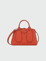 Cartera de mano modelo Le Roseau XS de Longchamp, confeccionada en cuero color terracota, con cierre de broche metálico distintivo y asas cortas.