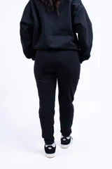 Conjunto deportivo compuesto por una campera corta con cierre frontal y un pantalón tipo jogging, ambos en color blanco.