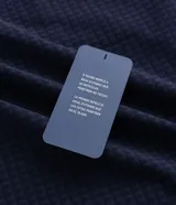 Chaqueta deportiva masculina de color azul marino, confeccionada en tejido técnico repelente al agua con acabado texturizado. Presenta cierre frontal con cremallera, capucha integrada y estampado de coordenadas en el pecho.